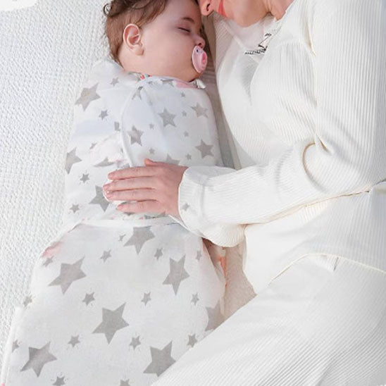 couverture emmaillotage étoiles blanc bébé dort bras maman